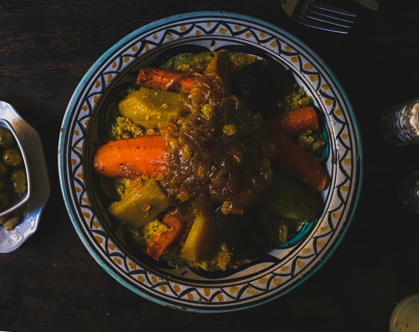 Couscous aux légumes servi dans un plat marocain peint