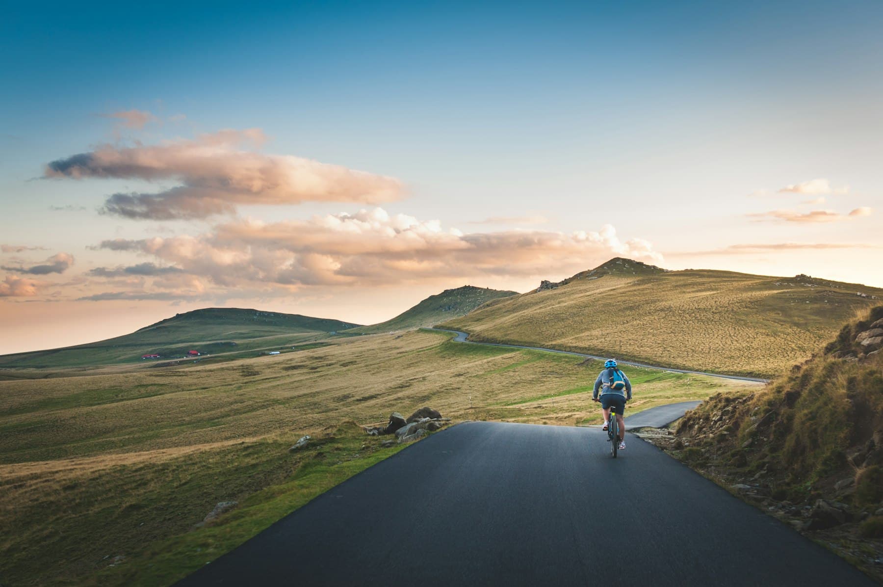 Cycliste sur une route de campagne entre les collines