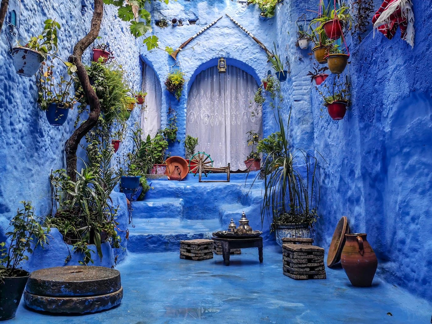Cour bleue d'une maison marocaine traditionnelle, plantes et poteries